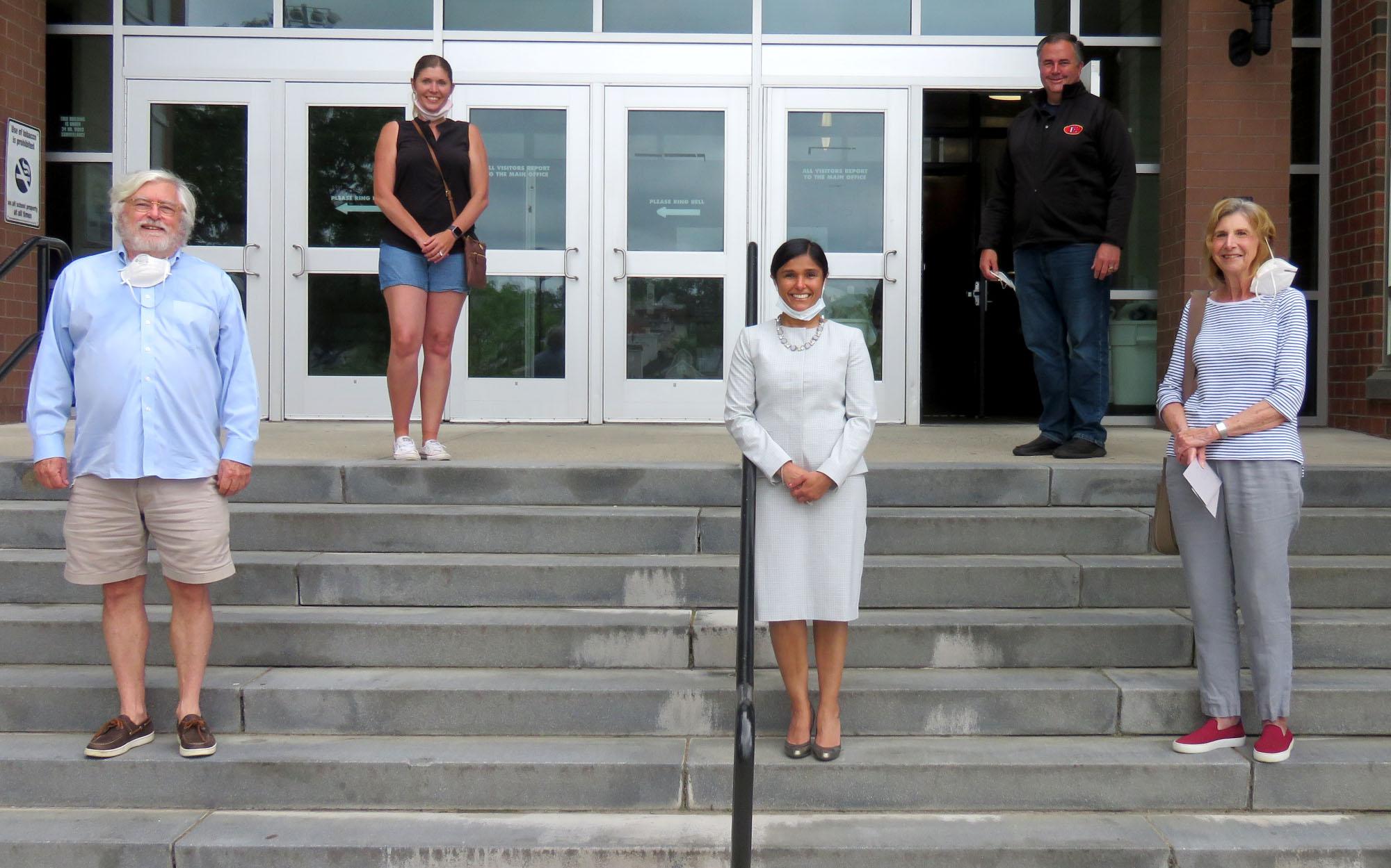 Posed photo, current and retired educators on the steps of Everett High